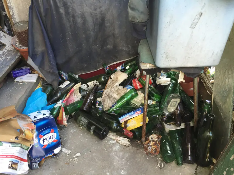 Bouteilles et déchets accumulés au sol avant débarras